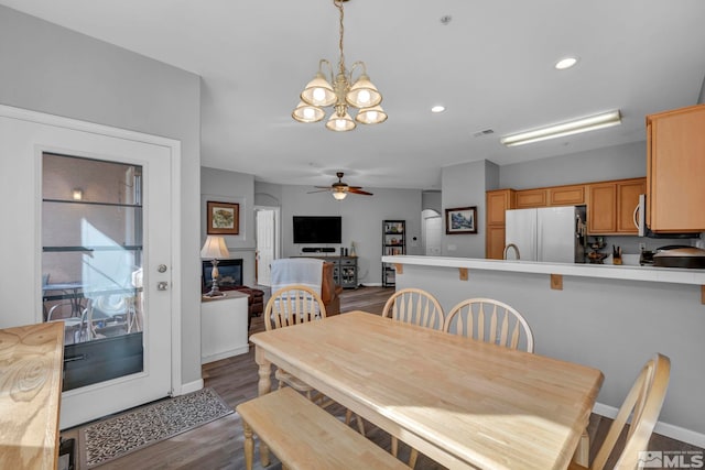 dining space with recessed lighting, ceiling fan with notable chandelier, dark wood-type flooring, visible vents, and baseboards