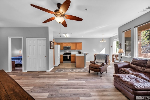 living area featuring recessed lighting, visible vents, light wood-style floors, baseboards, and ceiling fan with notable chandelier