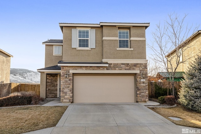 traditional-style home with stucco siding, a mountain view, fence, stone siding, and driveway