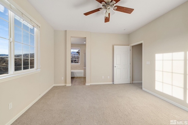 unfurnished bedroom with baseboards, connected bathroom, and light colored carpet