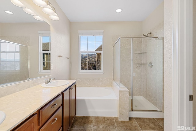 bathroom with double vanity, a stall shower, tile patterned floors, a garden tub, and a sink