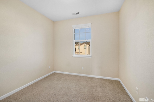 unfurnished room with carpet, visible vents, and baseboards