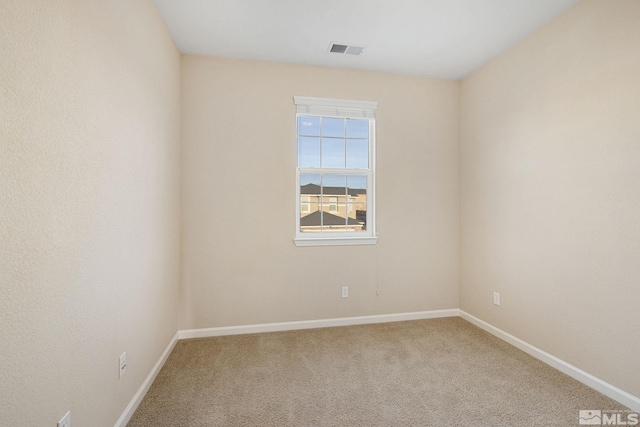 empty room featuring carpet, visible vents, and baseboards