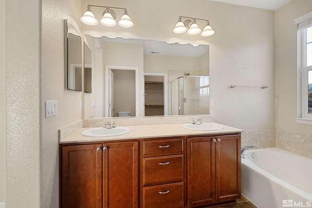 bathroom with toilet, a sink, a bath, and a shower stall