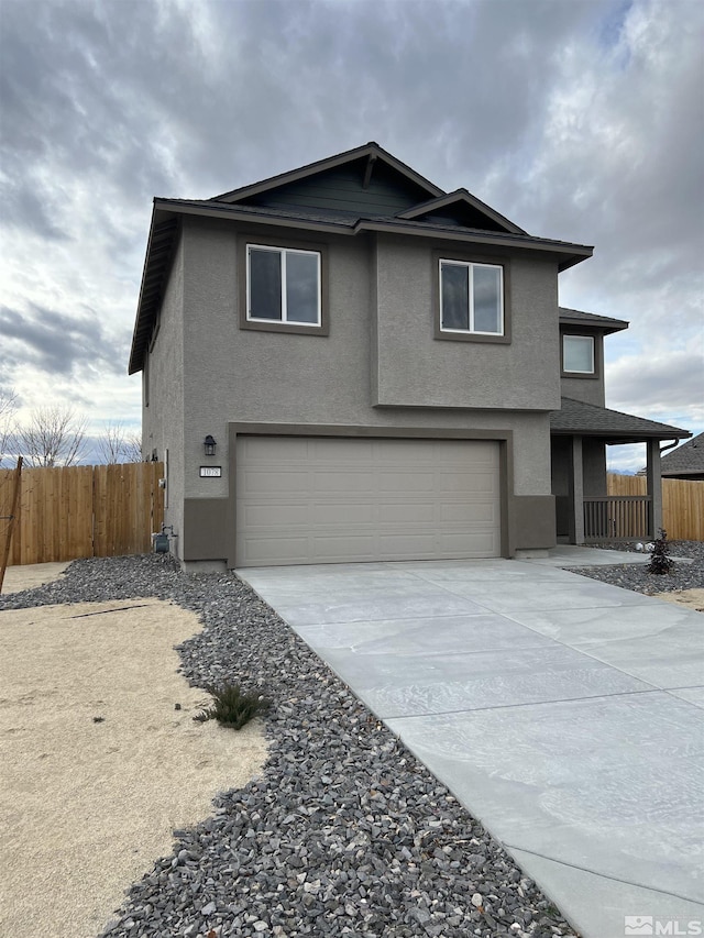 traditional home with a garage, concrete driveway, fence, and stucco siding