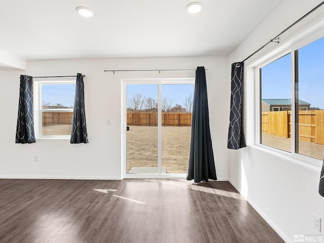 spare room featuring dark wood-style floors, recessed lighting, and baseboards