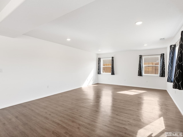 unfurnished room with dark wood-style flooring, recessed lighting, a wealth of natural light, and baseboards