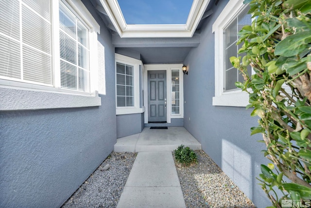 entrance to property featuring stucco siding