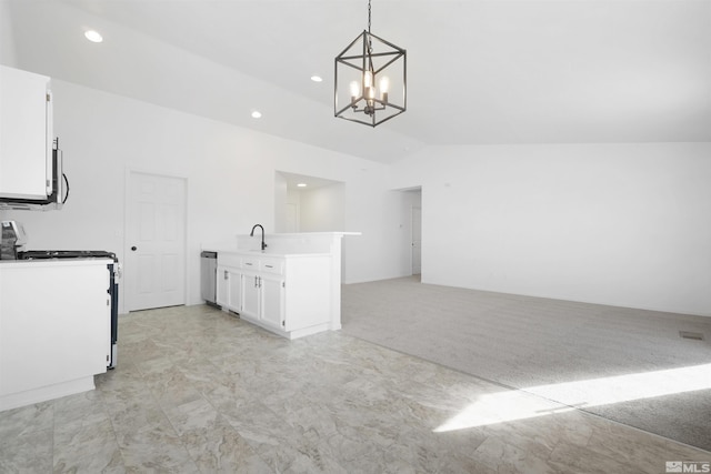 kitchen featuring lofted ceiling, appliances with stainless steel finishes, open floor plan, white cabinetry, and pendant lighting