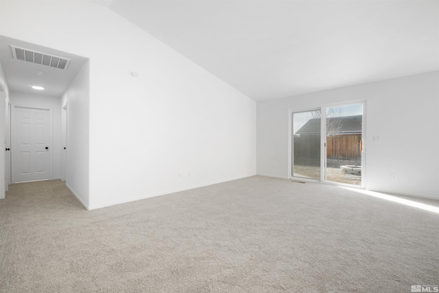 unfurnished room featuring light colored carpet, lofted ceiling, and visible vents