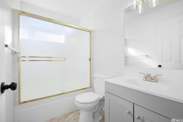 bathroom featuring combined bath / shower with glass door, vanity, and toilet