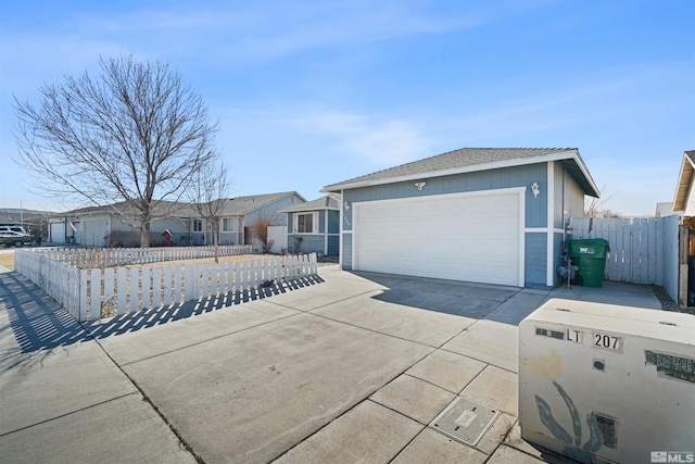 single story home featuring a fenced front yard, a residential view, concrete driveway, and a garage