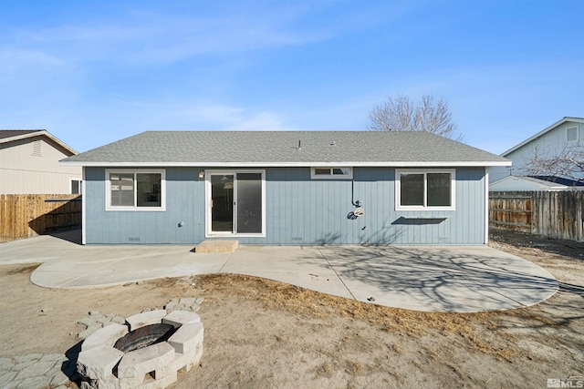 rear view of house featuring an outdoor fire pit, a shingled roof, a fenced backyard, and a patio