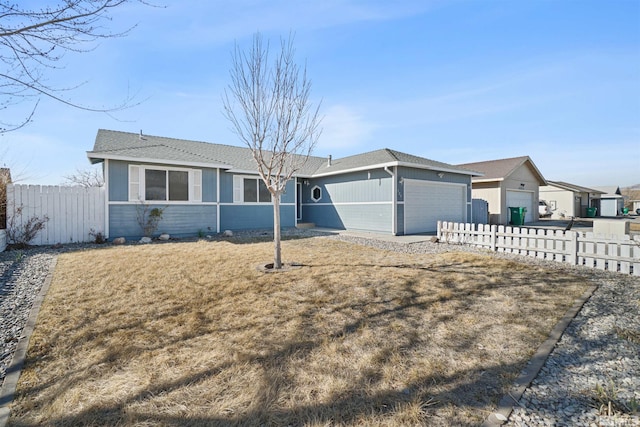 single story home featuring a garage, driveway, fence, and a front yard