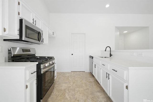 kitchen with stainless steel appliances, recessed lighting, light countertops, white cabinets, and a sink