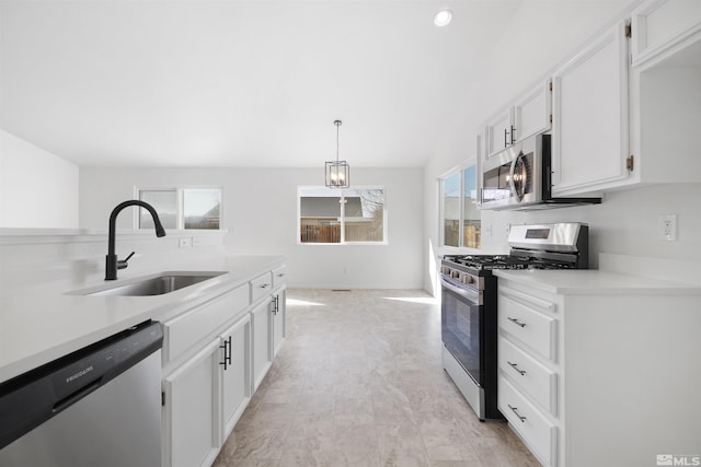 kitchen with white cabinets, appliances with stainless steel finishes, light countertops, and a sink