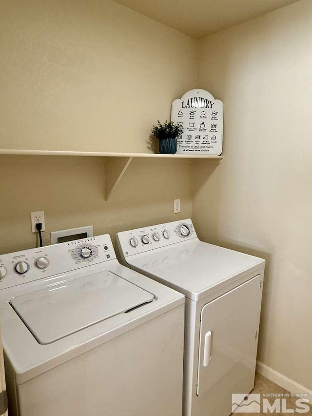 washroom featuring washing machine and dryer, laundry area, and baseboards