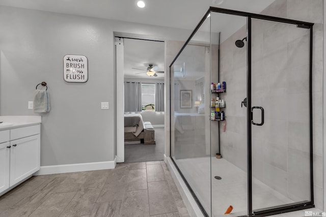 full bath featuring baseboards, a ceiling fan, connected bathroom, vanity, and a shower stall