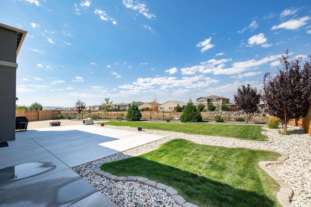 view of yard with a patio, a fenced backyard, and a residential view