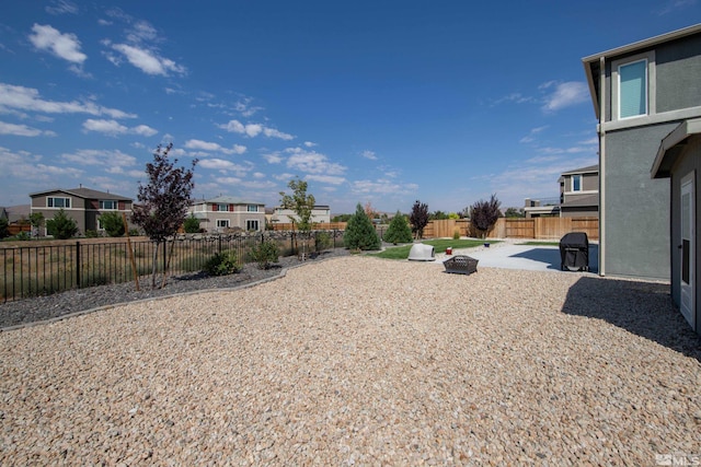 view of yard with a residential view, a fenced backyard, and a patio