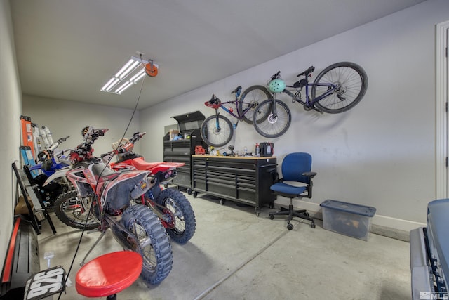 garage with baseboards and a workshop area