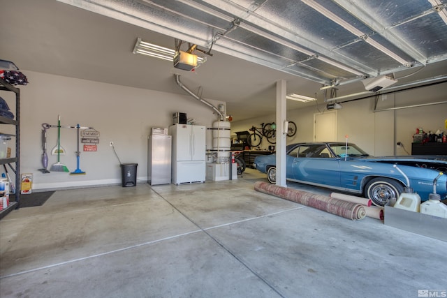 garage featuring stainless steel fridge, a garage door opener, and freestanding refrigerator