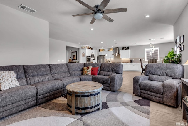 living area featuring recessed lighting, visible vents, and ceiling fan with notable chandelier