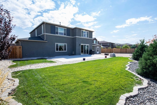 rear view of property with a patio area, a fenced backyard, a yard, and stucco siding