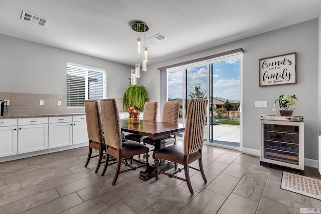 dining area featuring wine cooler, visible vents, and baseboards