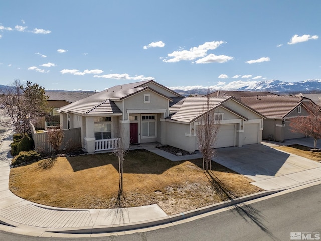 single story home with a tile roof, stucco siding, concrete driveway, an attached garage, and a mountain view