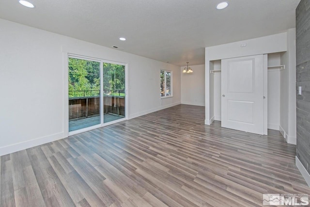 unfurnished living room featuring a chandelier, baseboards, visible vents, and light wood finished floors