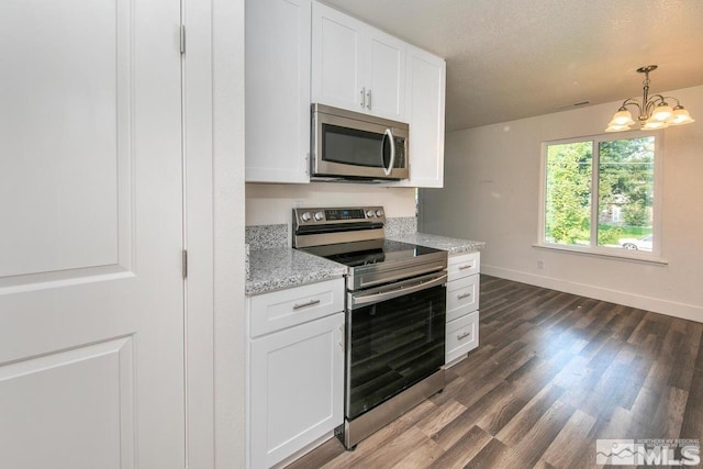 kitchen with dark wood-type flooring, light stone countertops, stainless steel appliances, a textured ceiling, and white cabinetry