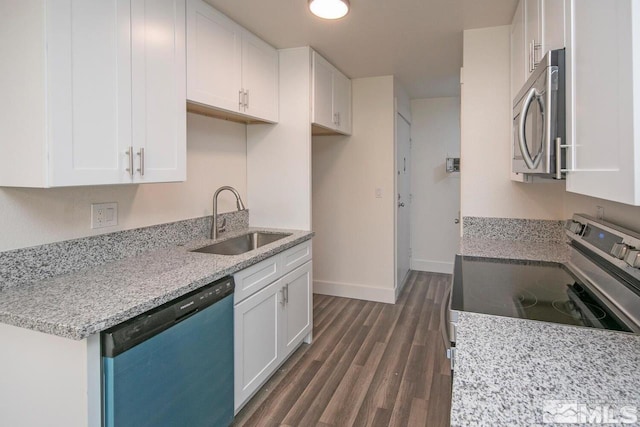 kitchen with light stone counters, stainless steel appliances, dark wood-style flooring, a sink, and white cabinets