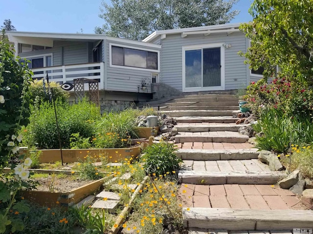 rear view of property featuring a garden