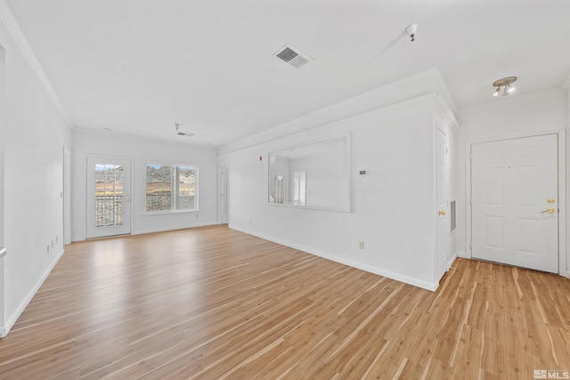 unfurnished living room with crown molding, light wood-style flooring, visible vents, and baseboards