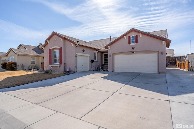 view of front of home featuring a garage, driveway, and stucco siding