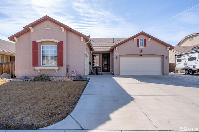 view of front facade with a garage, driveway, a tile roof, and stucco siding