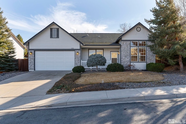 view of front of house with a garage, stone siding, a shingled roof, and driveway