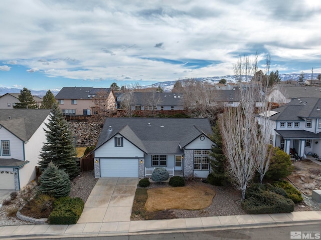 view of front of property with a garage, a residential view, driveway, and a mountain view