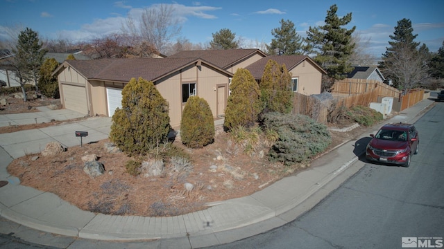 ranch-style house with a garage and fence