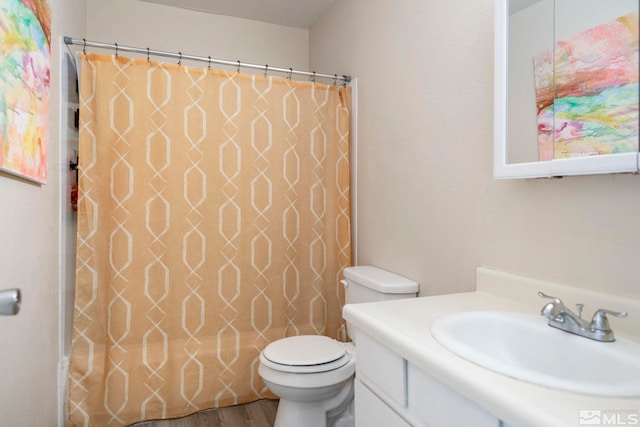 bathroom with vanity, curtained shower, wood finished floors, and toilet