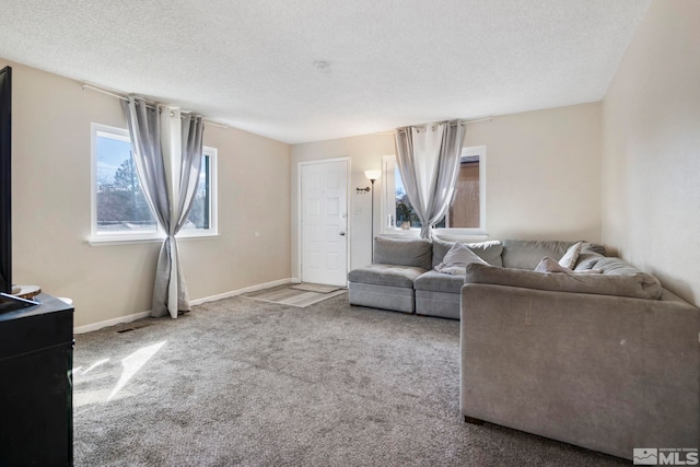 living area featuring visible vents, carpet flooring, a textured ceiling, and baseboards