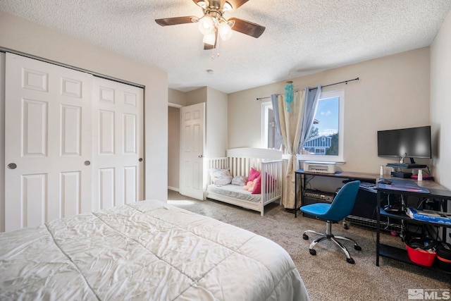 bedroom featuring a textured ceiling, a closet, a ceiling fan, and carpet flooring