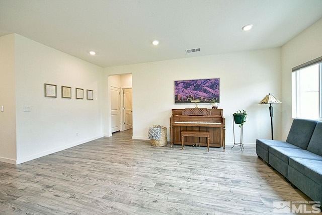 living area featuring baseboards, wood finished floors, visible vents, and recessed lighting