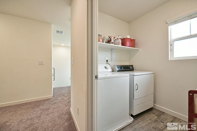 laundry area featuring laundry area, visible vents, baseboards, light wood-style floors, and washer and dryer