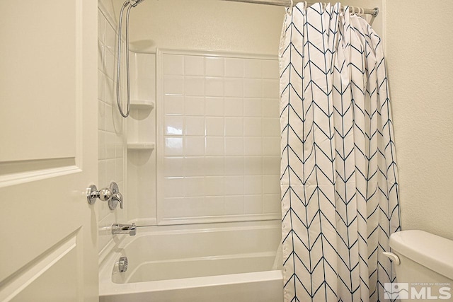 bathroom featuring a textured wall, toilet, and shower / bath combo with shower curtain