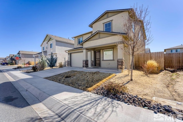 view of front facade featuring concrete driveway, fence, and stucco siding