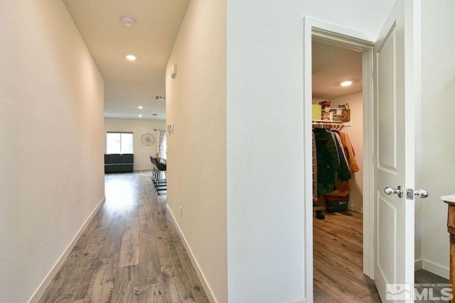 hallway featuring recessed lighting, wood finished floors, and baseboards