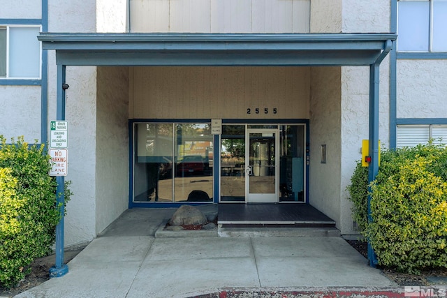 doorway to property featuring stucco siding