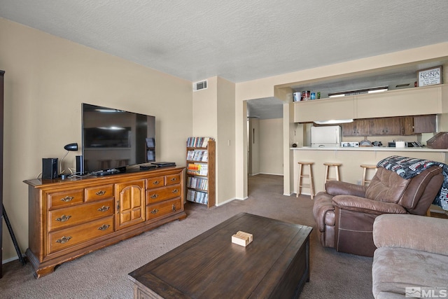 living room with carpet floors, visible vents, a textured ceiling, and baseboards